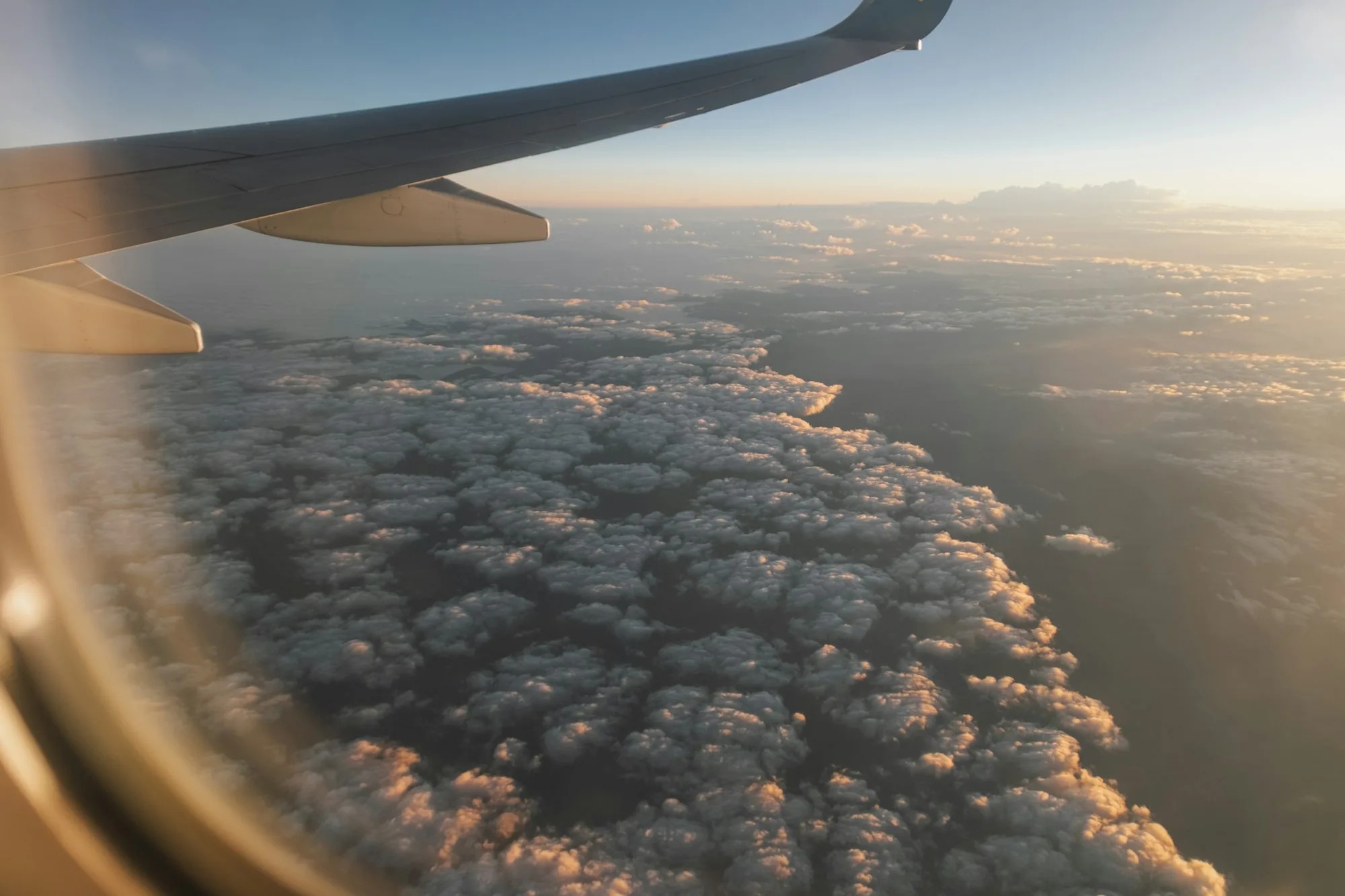 Aircraft wing viewed against changing cloud and weather conditions