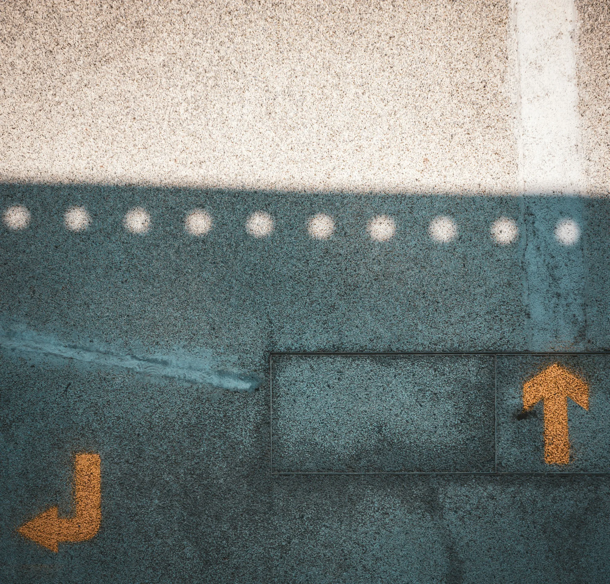 Orange directional arrow painted on an airport pavement surface